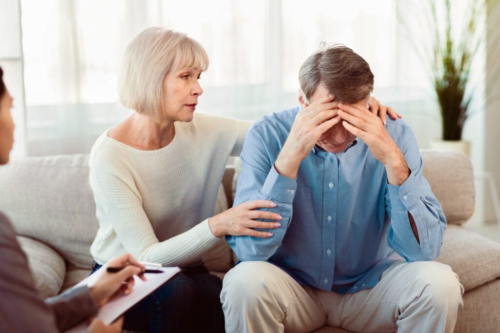 Elderly wife supports her husband during psychotherapy session