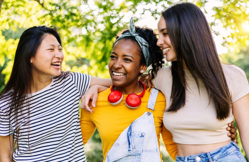 Younga group of three teenage girls having fun together outdoors