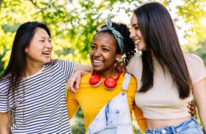 Younga group of three teenage girls having fun together outdoors